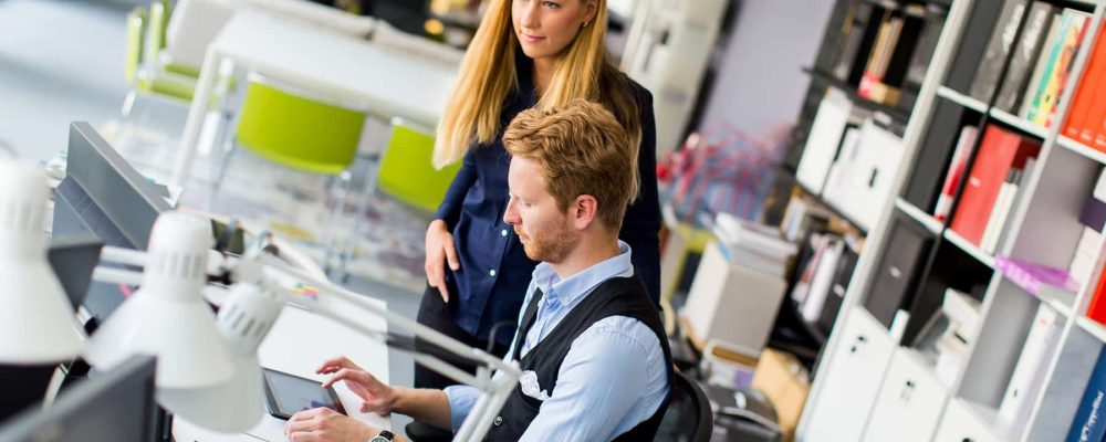 View at young business couple using laptop in the office